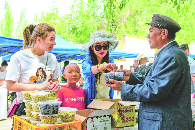 5月19日,游客在尉犁县兴平镇哈拉洪村购买当地土特产品 李飞摄