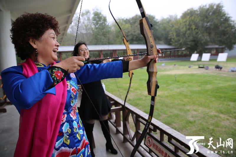 任艳摄影报道)10月6日,游客在察布查尔县国家级锡伯古城体验射箭乐趣